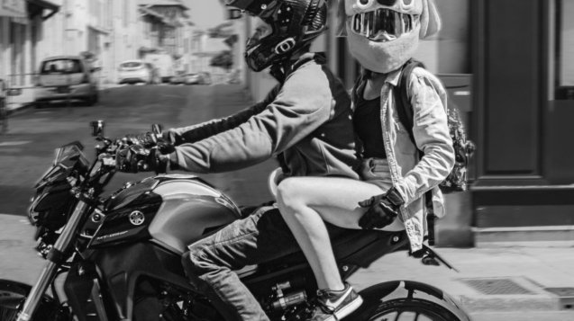 a couple of people riding on the back of a motorcycle