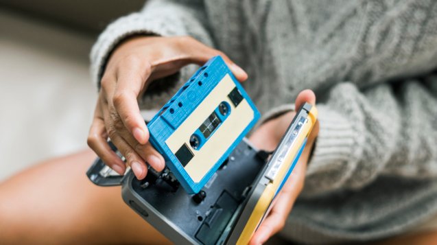 Woman putting a cassette in a cassette player